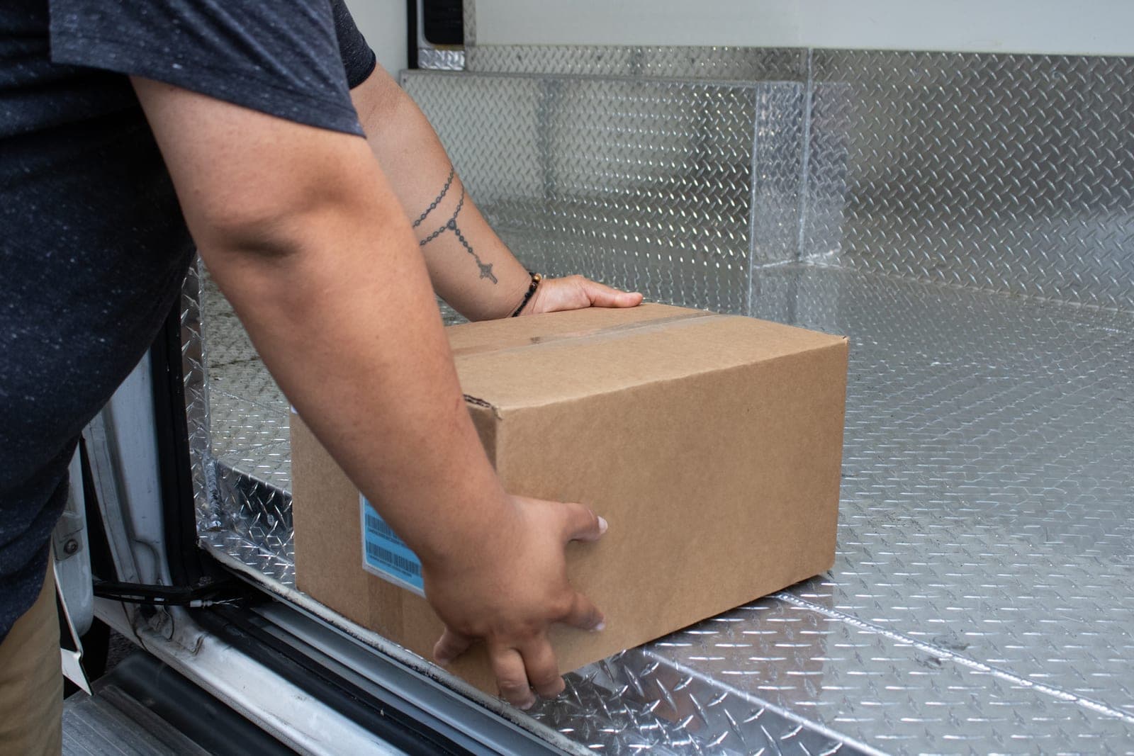 Bud Technology team member loading a sealed wholesale order into a delivery van for last-mile cannabis delivery